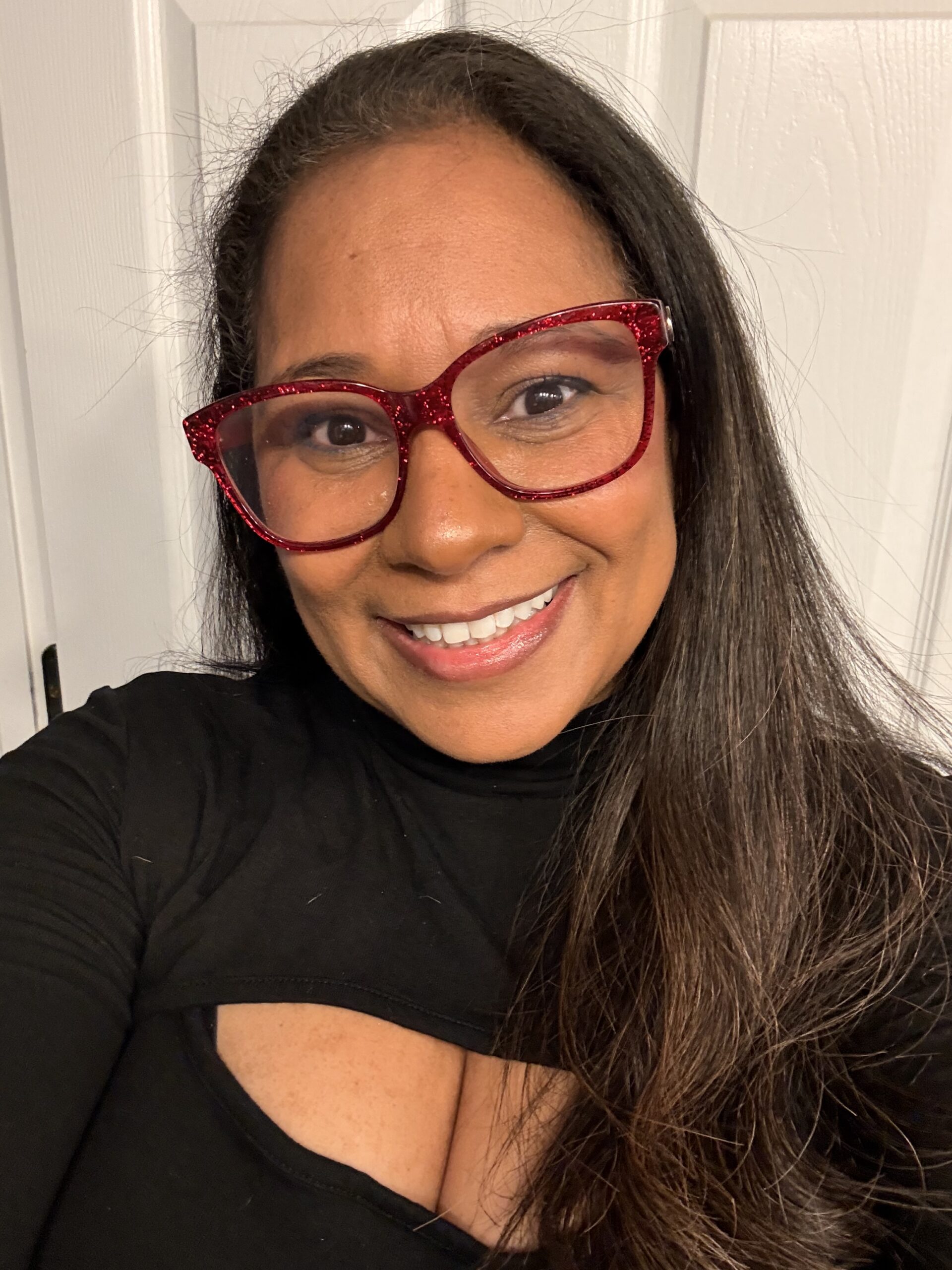 A picture on me an entrepreneur black women in a black top and red glasses